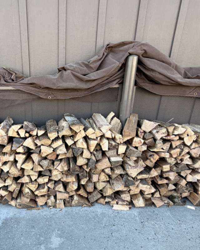 A commercial firewood rack fully stocked with split oak
